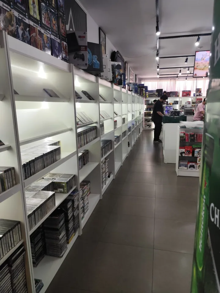 Corredor da Retroteka com estantes de jogos e consoles.